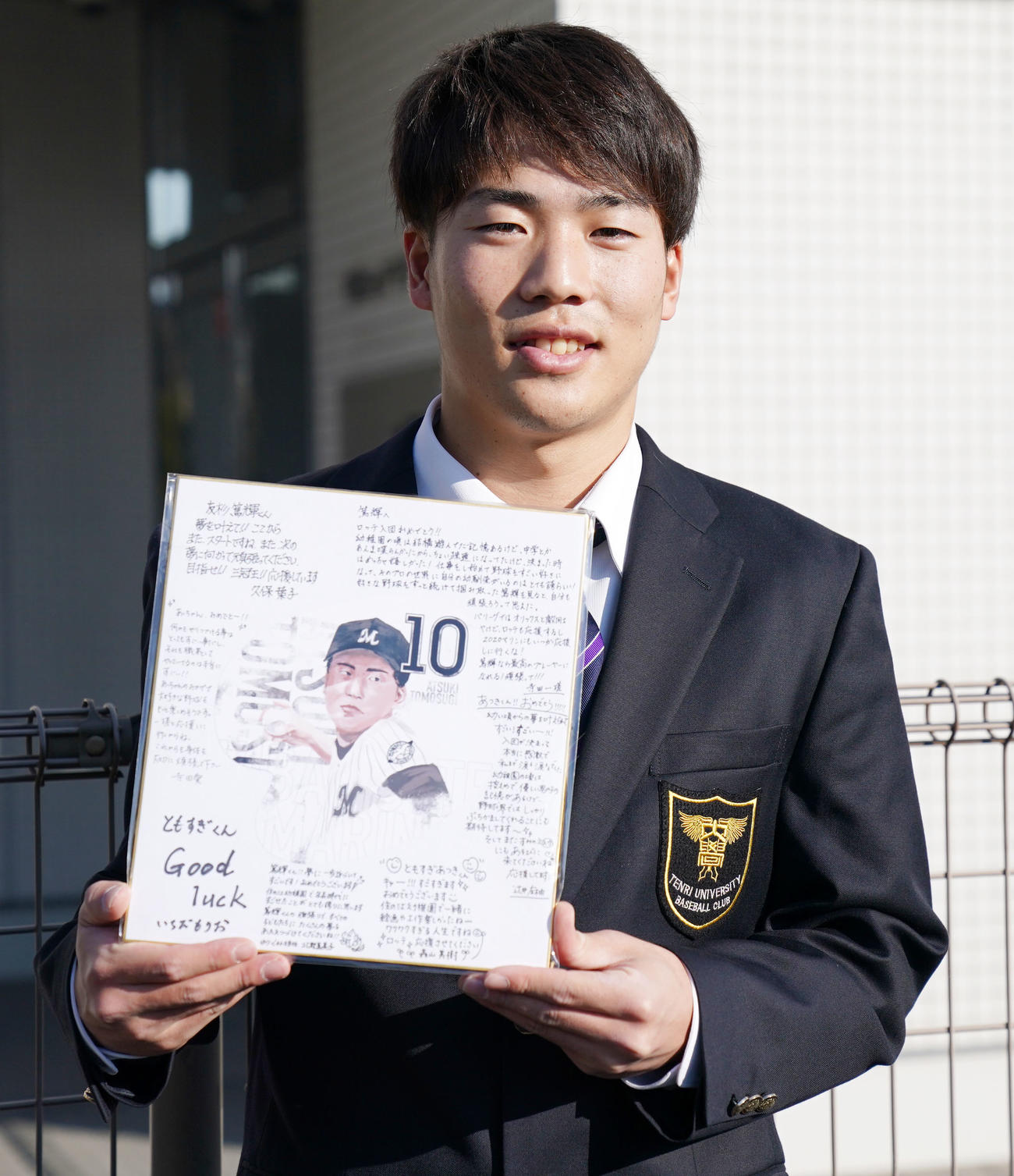 幼稚園からプレゼントされた寄せ書きを手に笑顔を見せるロッテドラフト2位友杉（撮影・横山健太）