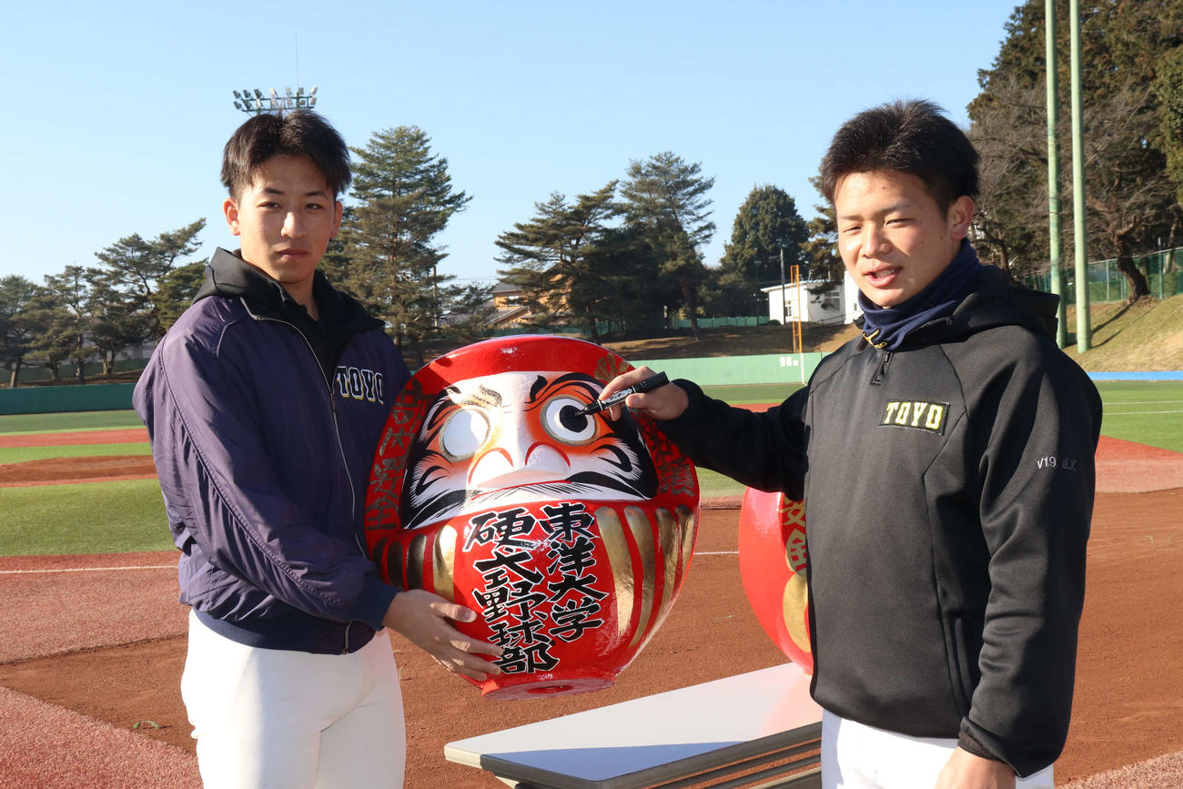 必勝祈願のだるまを持って記念撮影する東洋大・細野（左）と水谷（撮影・星夏穂）