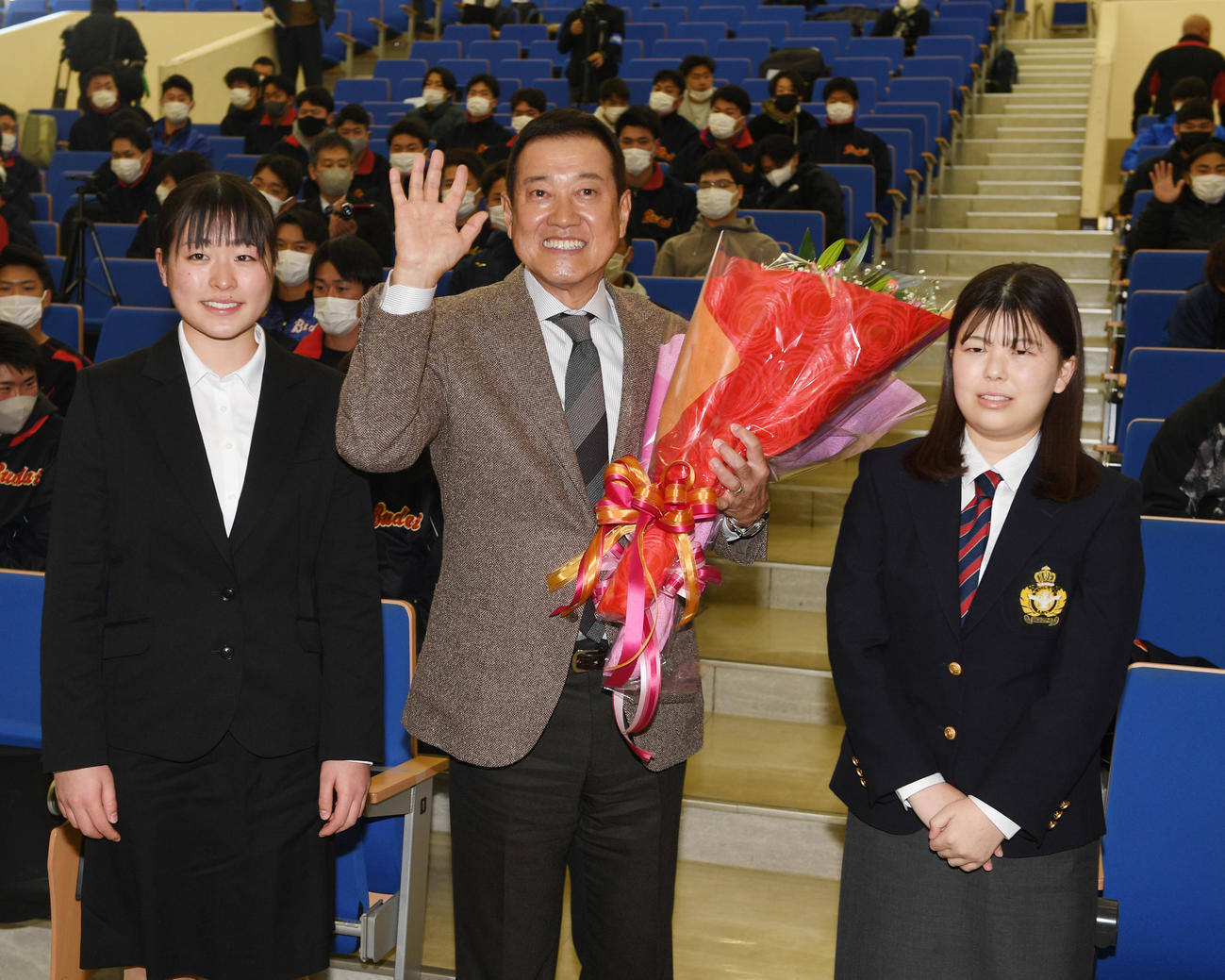 講義の後、学生から花束を贈られた原監督は笑顔で記念撮影に納まる（撮影・柴田隆二）