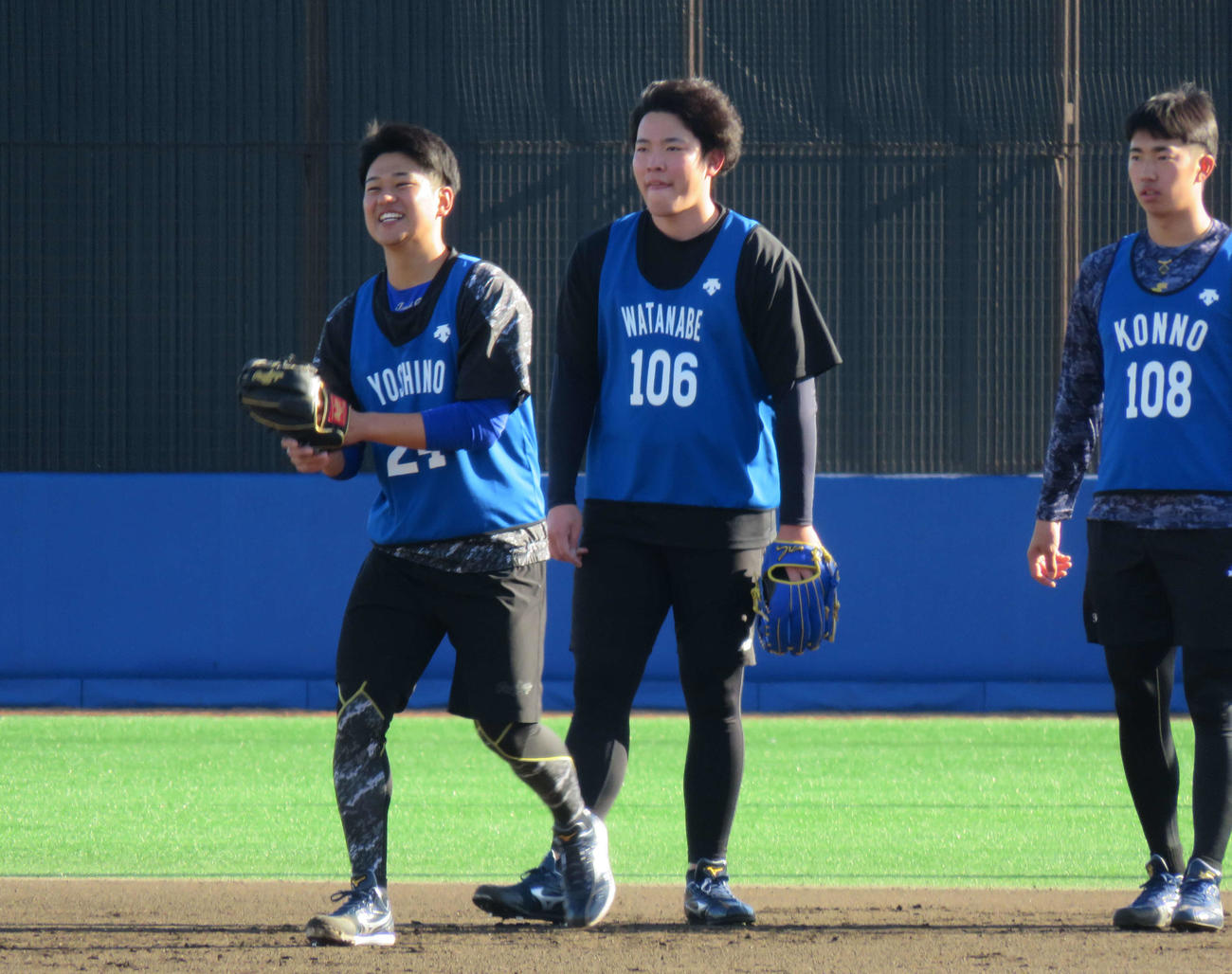 笑顔でノックを受けるDeNAのドラフト2位ルーキー、吉野（左）