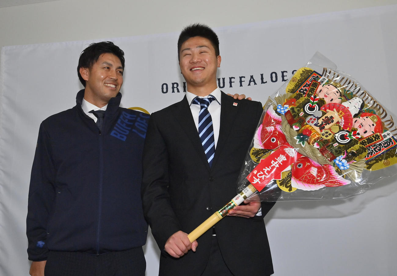 入寮し大経大前監督の山本和作オリックス広報（左）から激励される育成2位才木（撮影・和賀正仁）