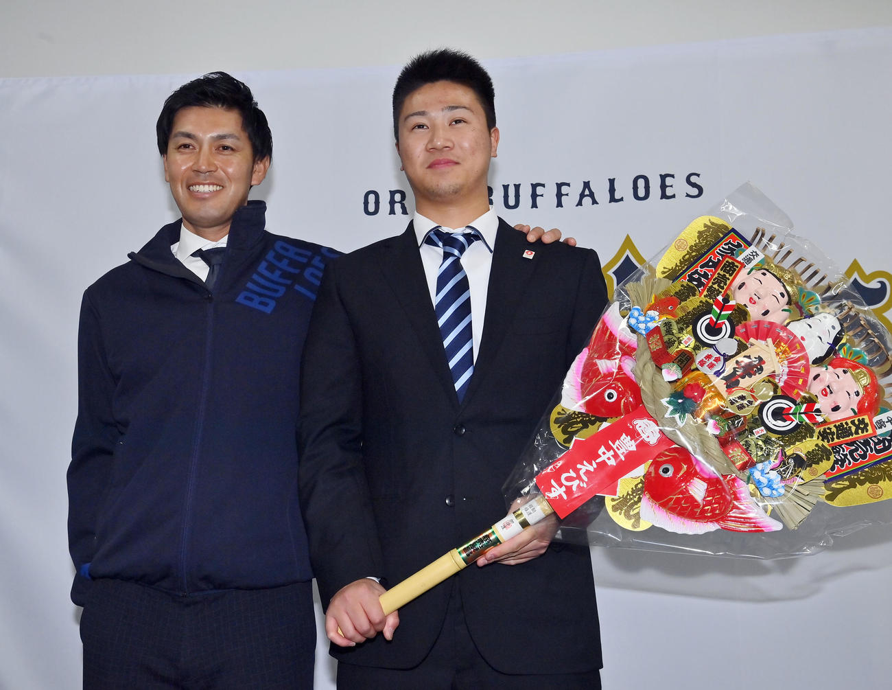 入寮し大経大前監督の山本和作オリックス広報（左）から激励される育成2位才木（撮影・和賀正仁）