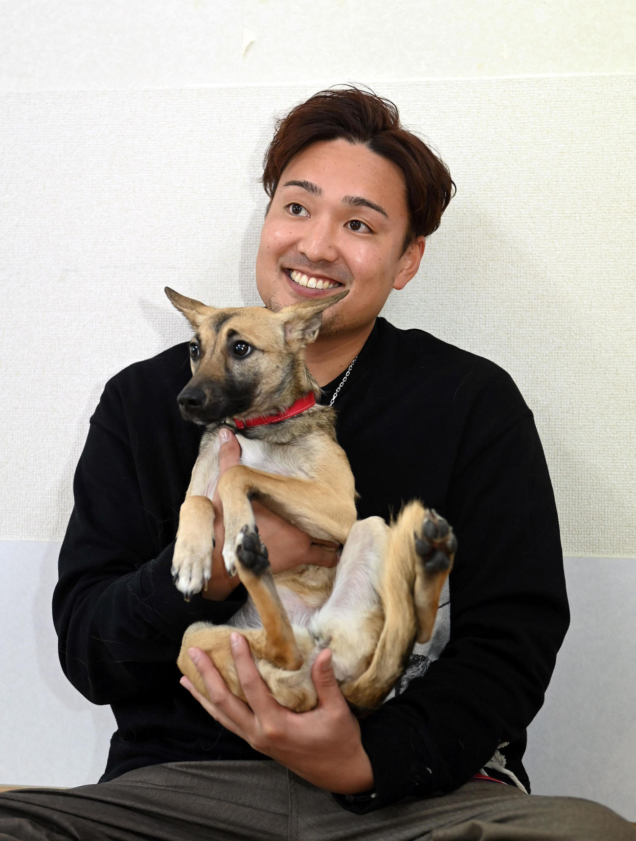 犬とふれ合い笑顔を見せる阪神秋山（代表撮影）