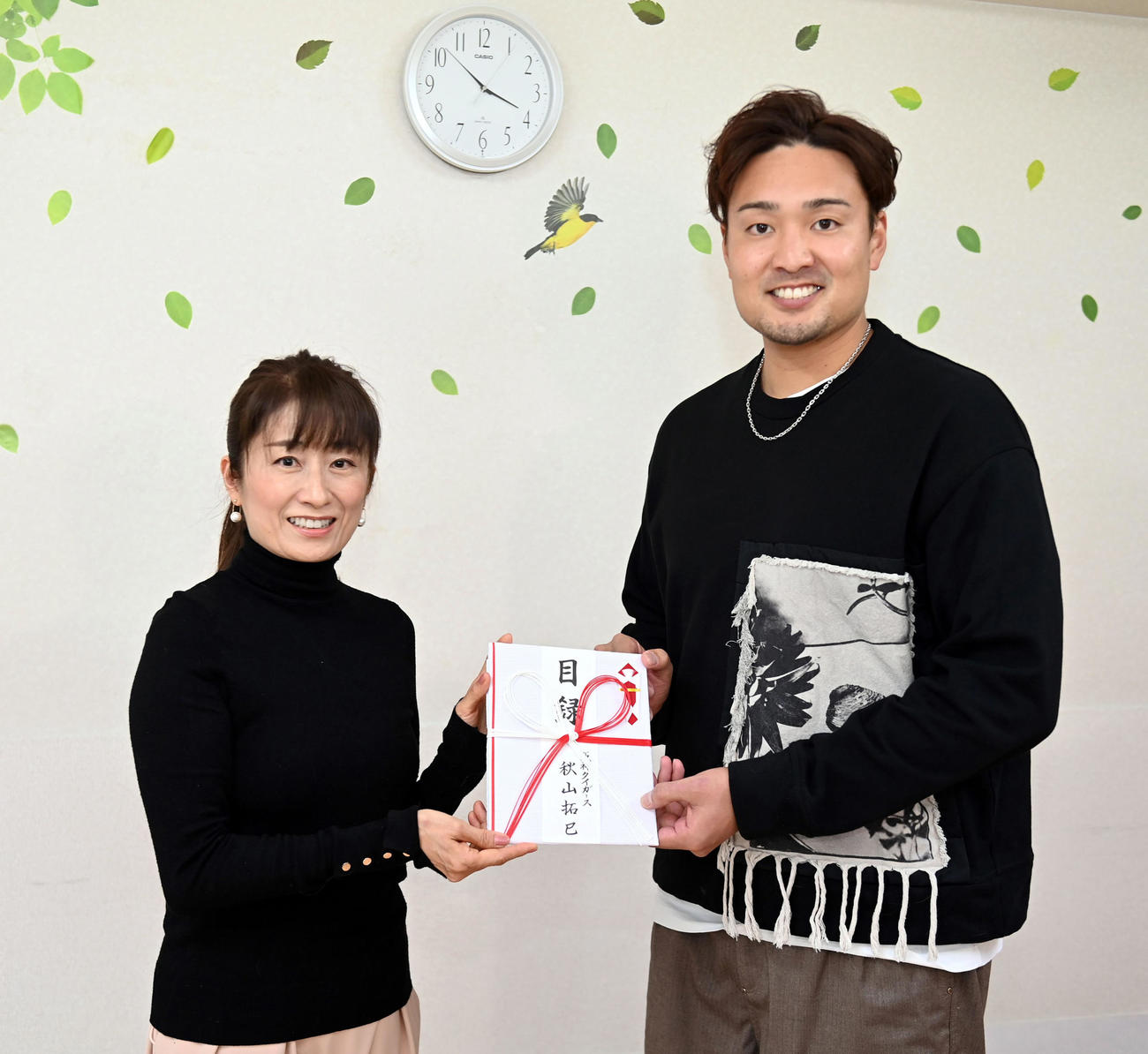 日本アニマル・ドネーションの西平衣里さん（左）に目録を手渡す阪神秋山（代表撮影）
