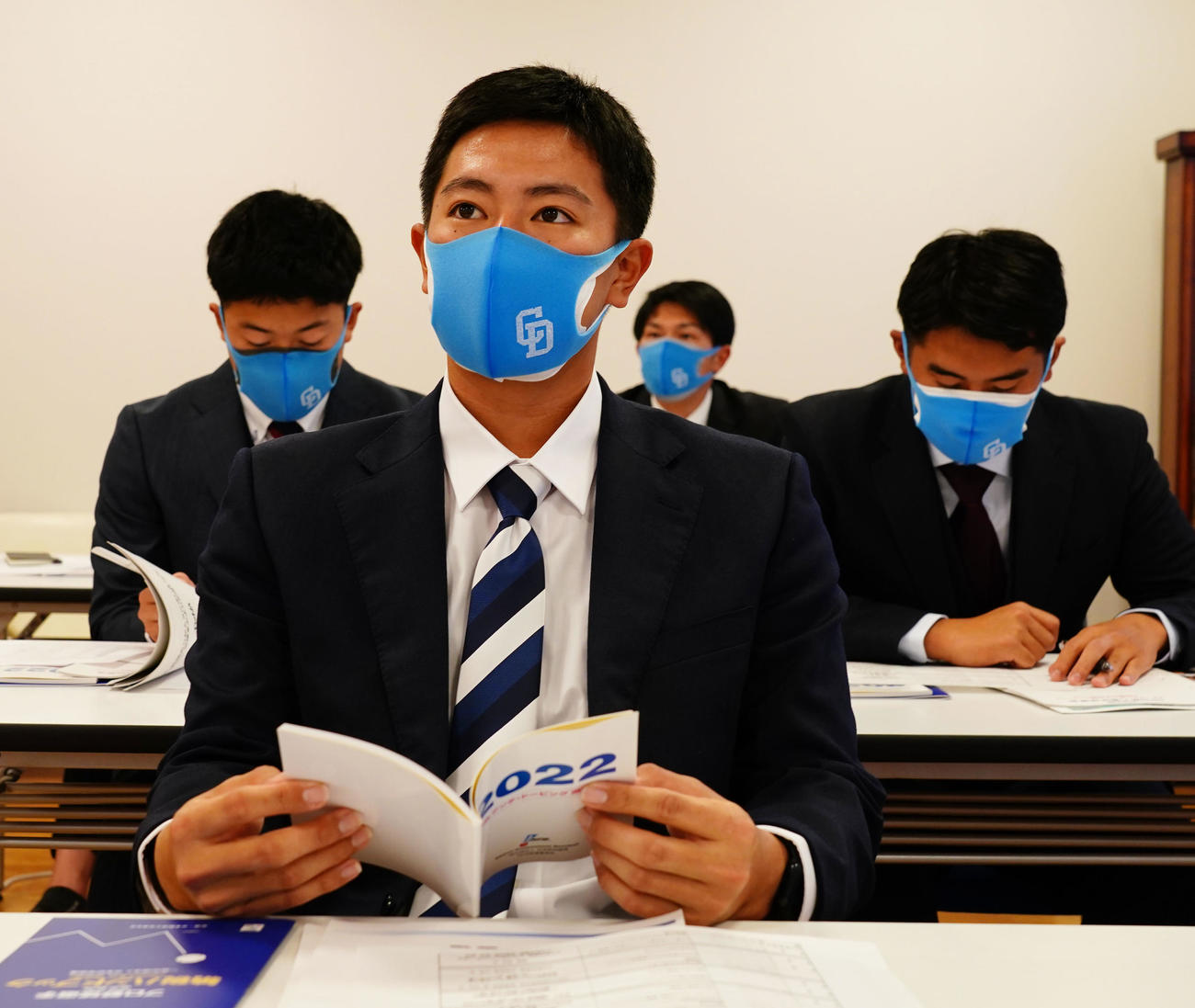 新人研修の席に着く仲地（手前）（中日ドラゴンズ球団提供）