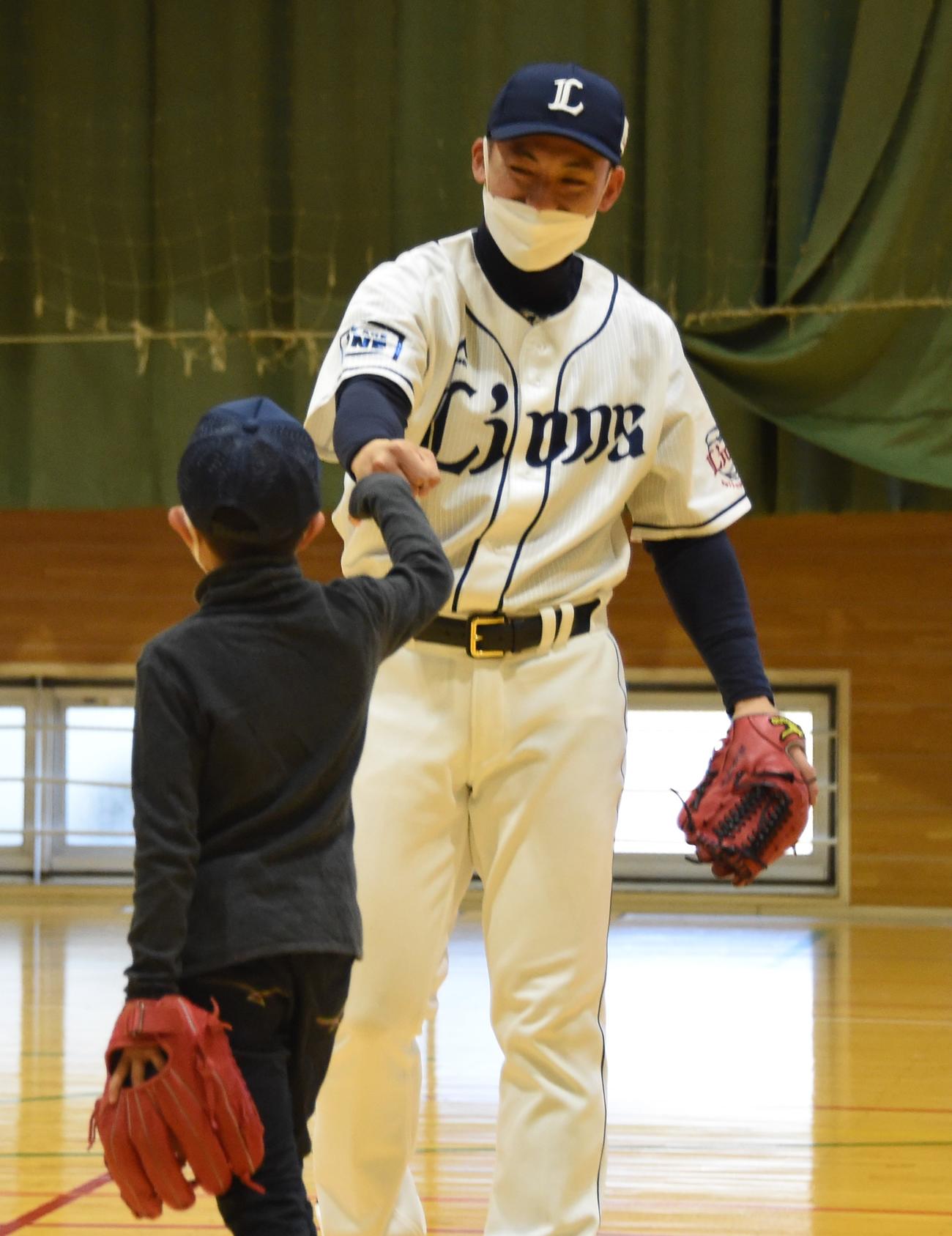 社会活動の一環で浜松医科大病院を訪れた西武栗山は、子どもとグータッチを交わす（撮影・鈴木正章）