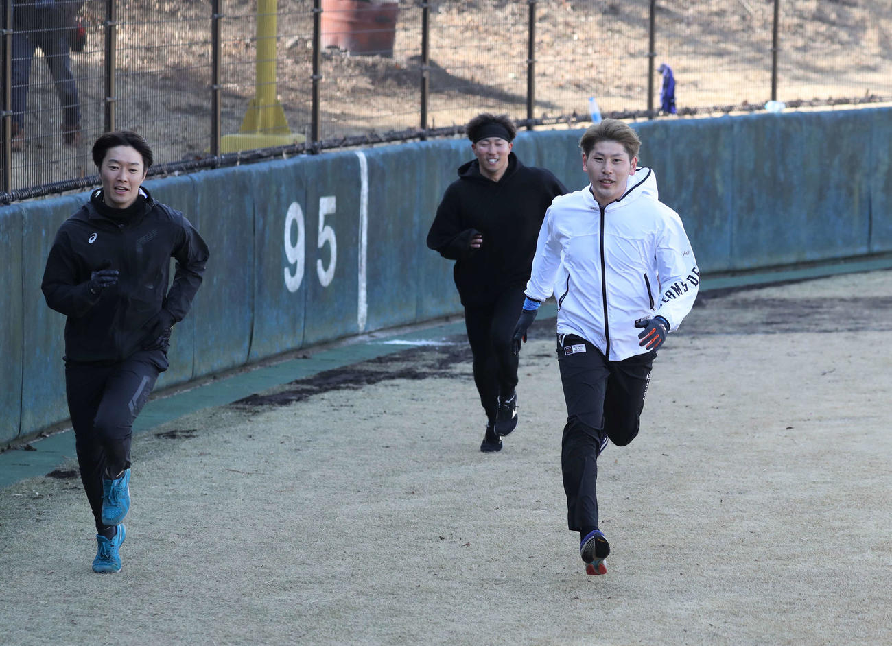 公開自主トレでフェンス際を笑顔でダッシュする左から日本ハム玉井、井口、加藤（撮影・黒川智章）