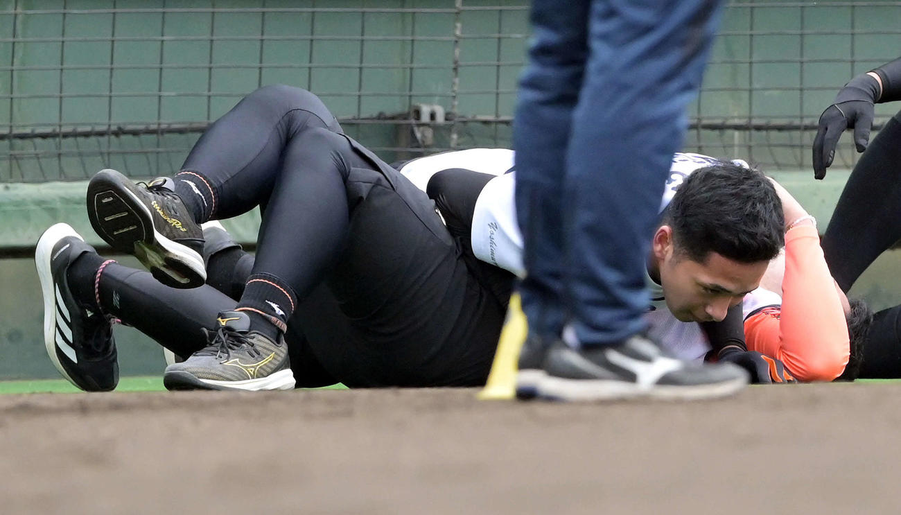 巨人新人合同自主トレの1500メートル走を終え倒れ込んだドラフト1位浅野（下）に覆いかぶさる育成3位吉村（撮影・滝沢徹郎）