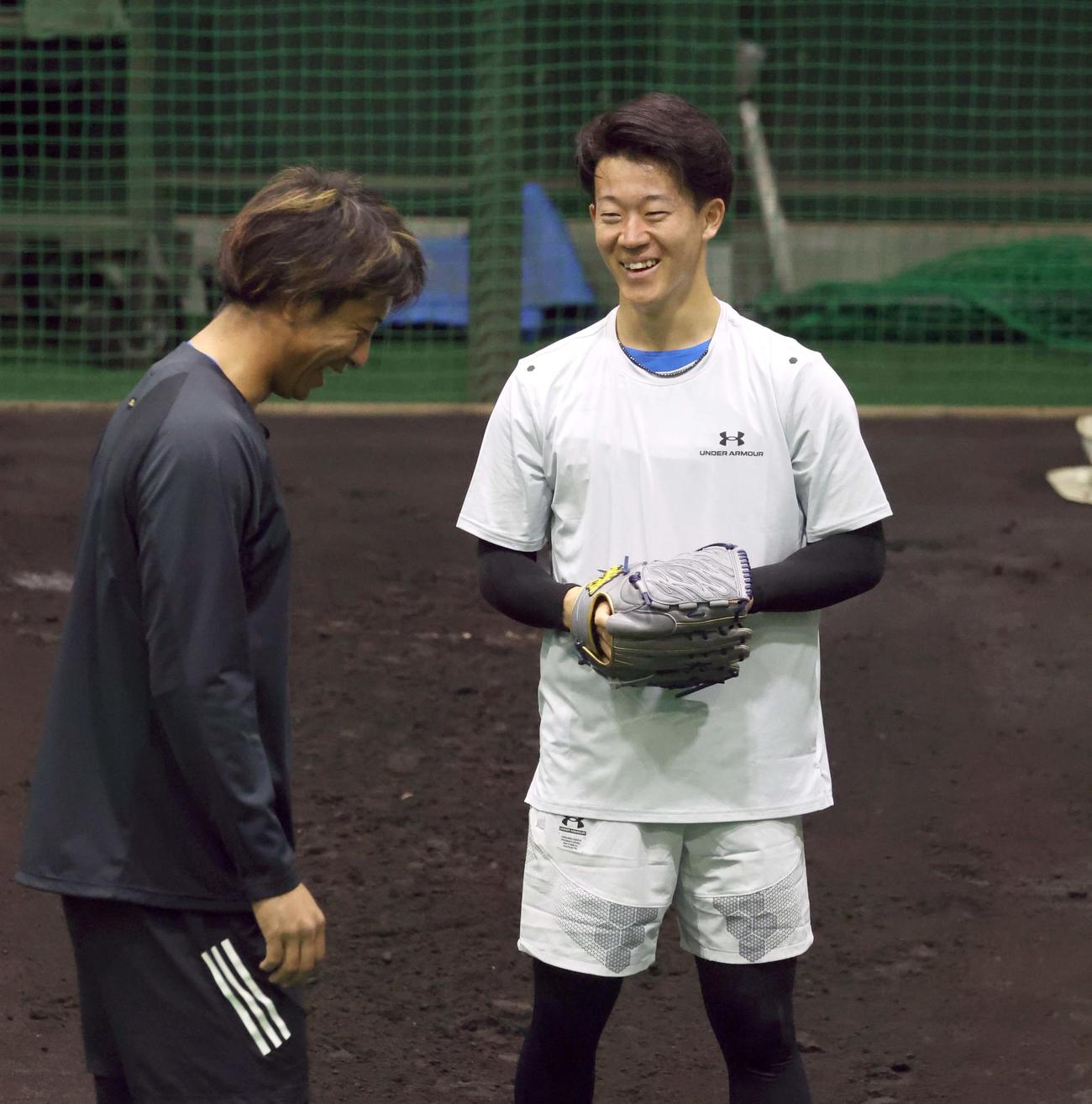ブルペンで投球後、捕手を務めた古川（左）と話す日本ハム矢沢（撮影・黒川智章）