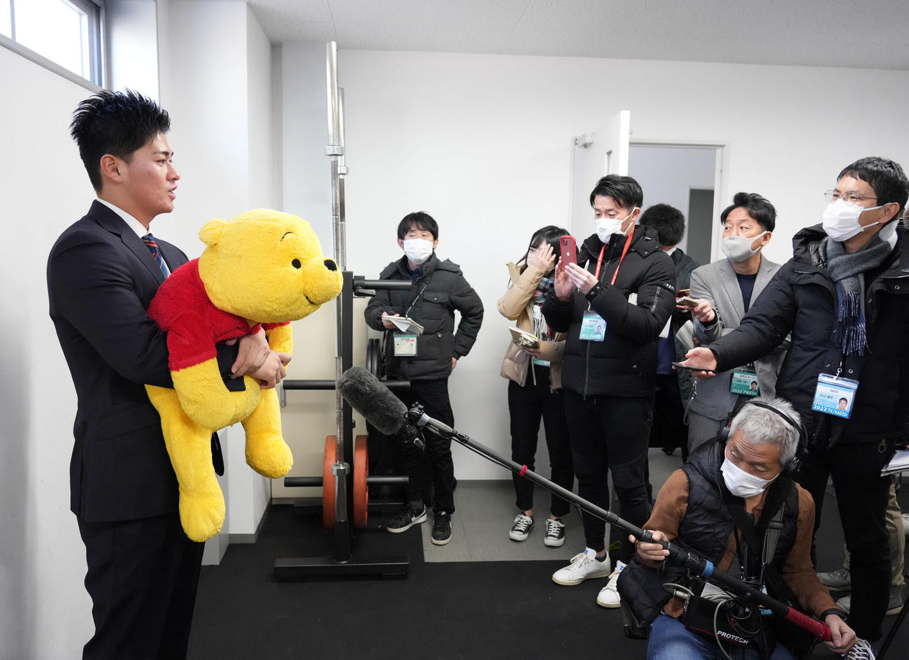 お気に入りのプーさんのぬいぐるみを抱え、インタビューに答えるドラフト5位のヤクルト北村（2023年1月7日）