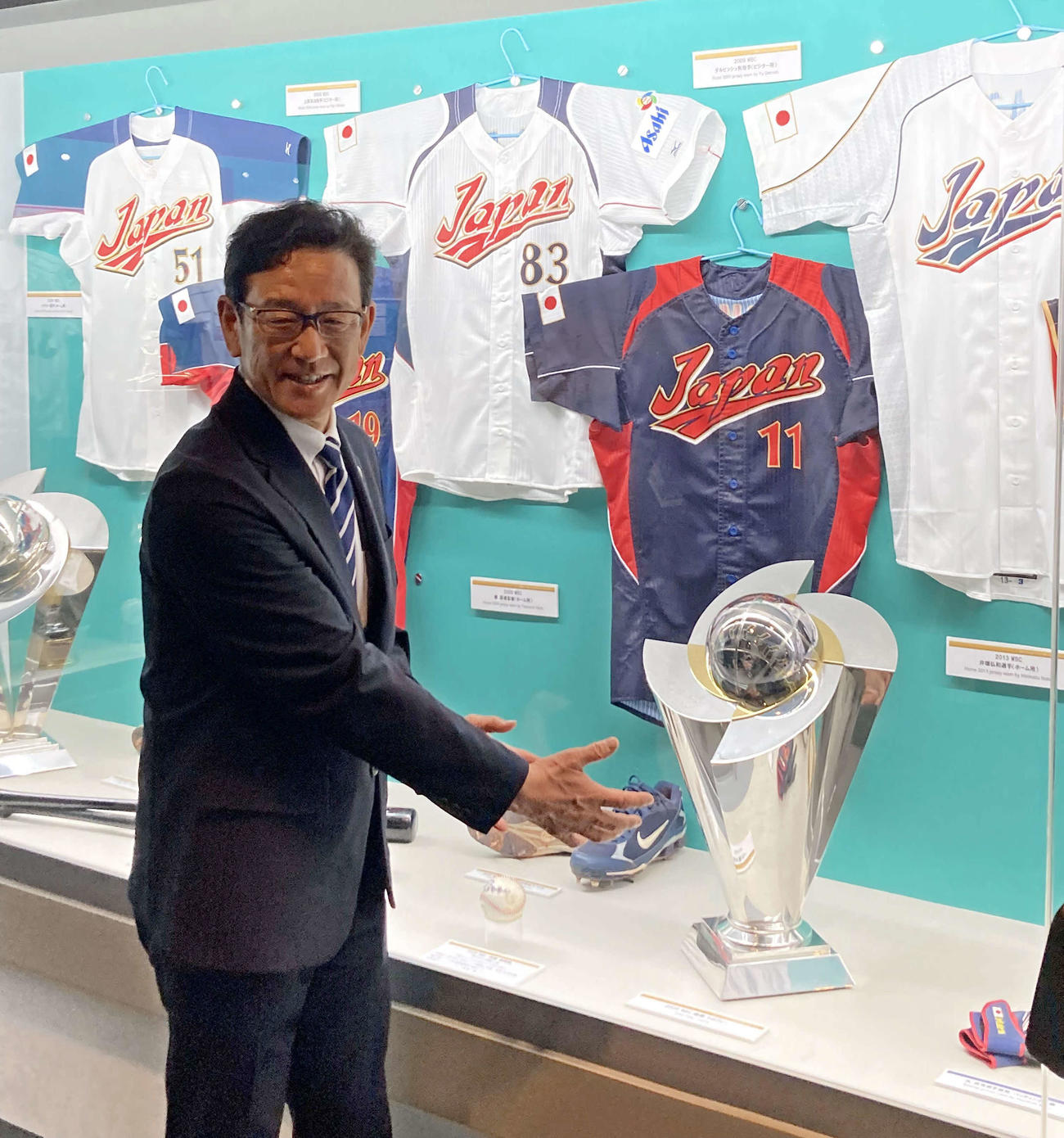 野球殿堂博物館の09年WBC優勝トロフィーの前で写真に納まる栗山監督（撮影・古川真弥）