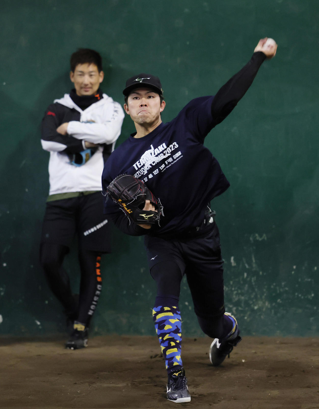 自主トレで阪神岩崎（左）が見つめる中、ブルペン投球する巨人山本（撮影・足立雅史）