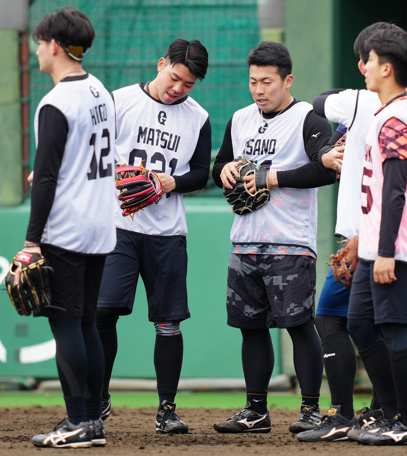 新人合同自主トレ中、互いのグラブを交換する巨人ドラフト1位の浅野（中央右）と育成1位の松井（撮影・江口和貴）