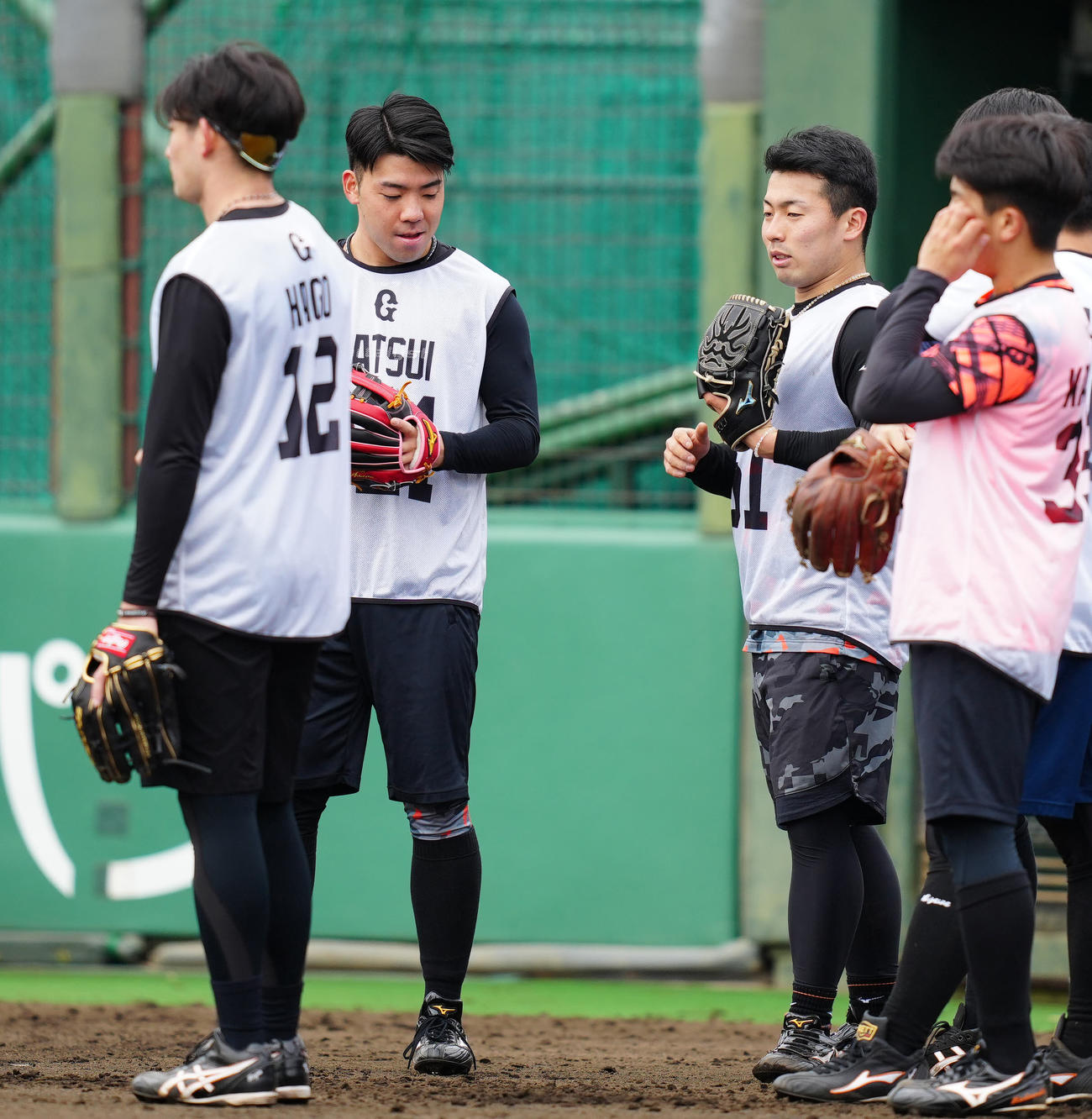 新人合同自主トレ中、互いのグラブを交換する巨人ドラフト1位の浅野（中央右）と育成1位の松井（撮影・江口和貴）