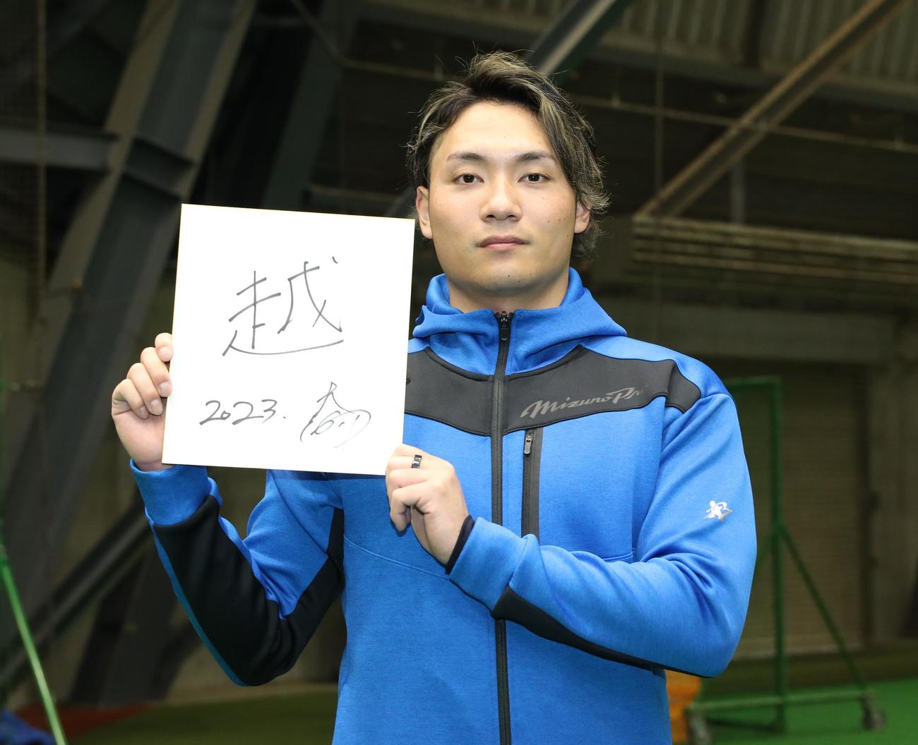 「越」と書いた色紙を掲げる日本ハム伊藤（撮影・黒川智章）