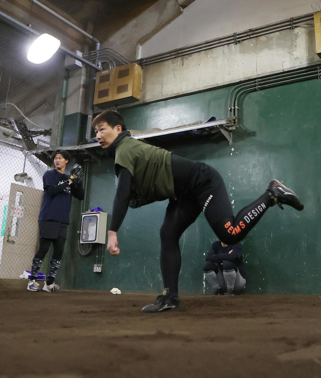 自主トレでブルペン投球する阪神の岩崎（右）と及川（撮影・足立雅史）