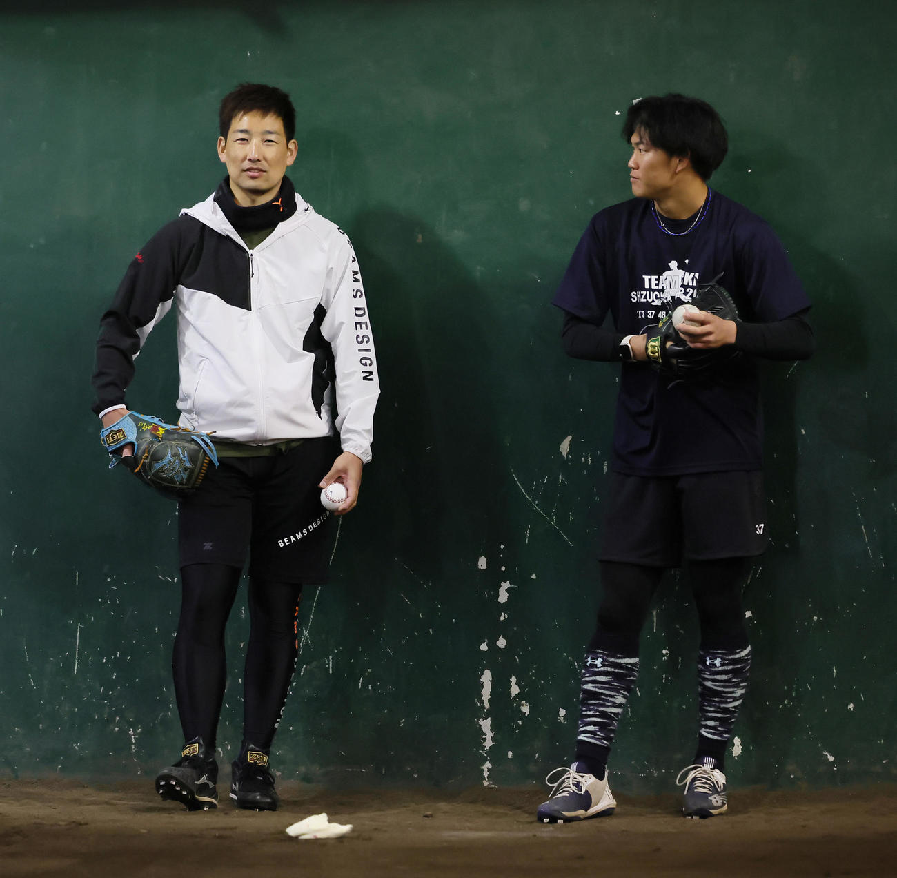 自主トレのブルペン会話を交わす阪神の岩崎（左）と及川（撮影・足立雅史）