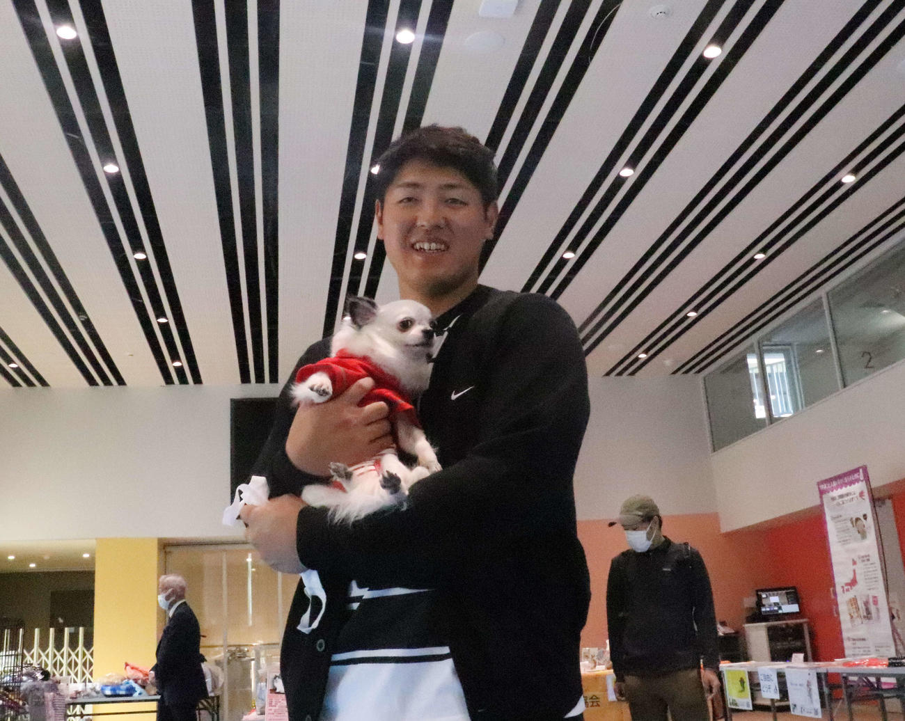 犬を抱きかかえながら笑顔を見せる巨人岡本和（撮影・小早川宗一郎）