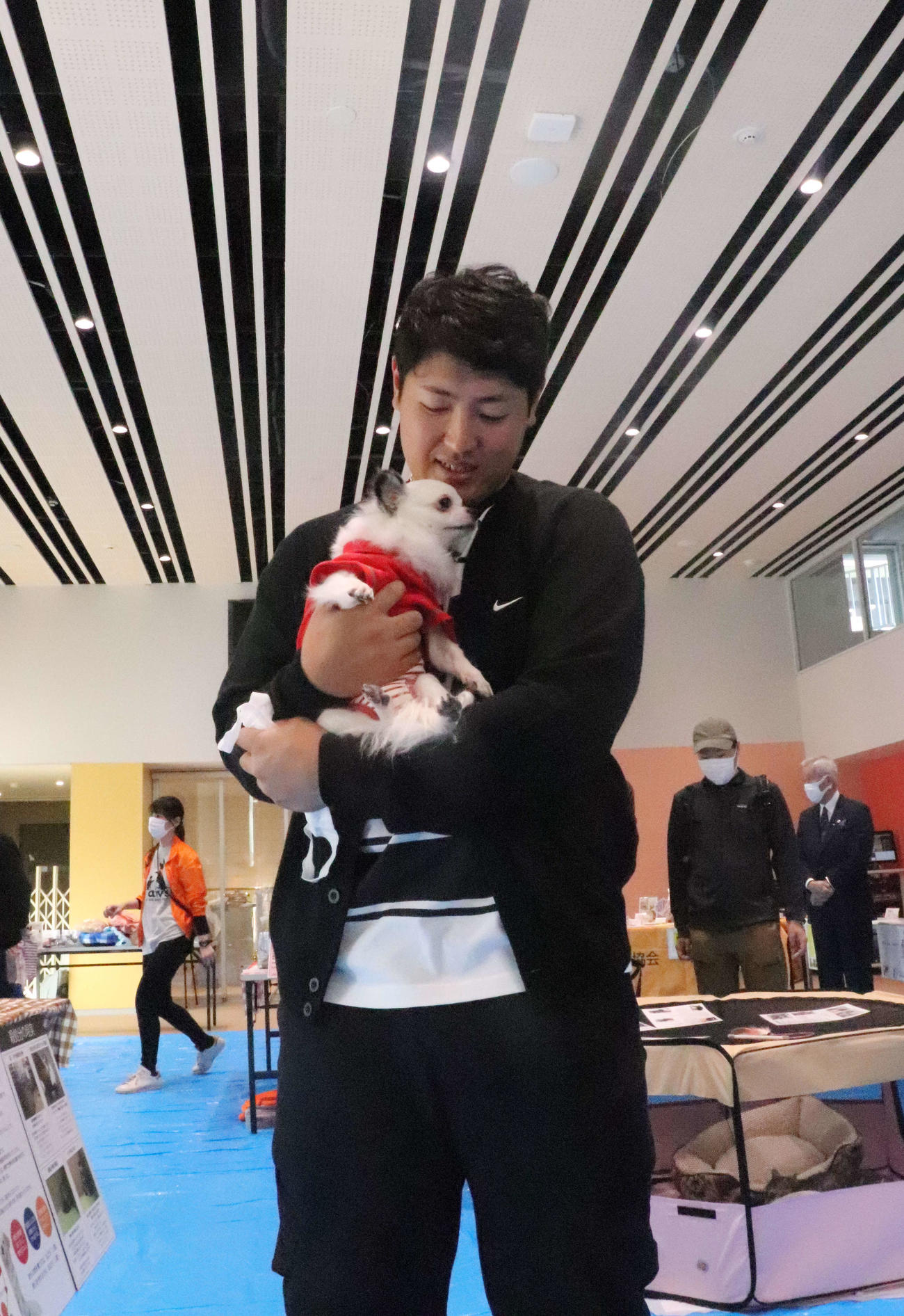 犬を抱きかかえながら笑顔を見せる巨人岡本和（撮影・小早川宗一郎）