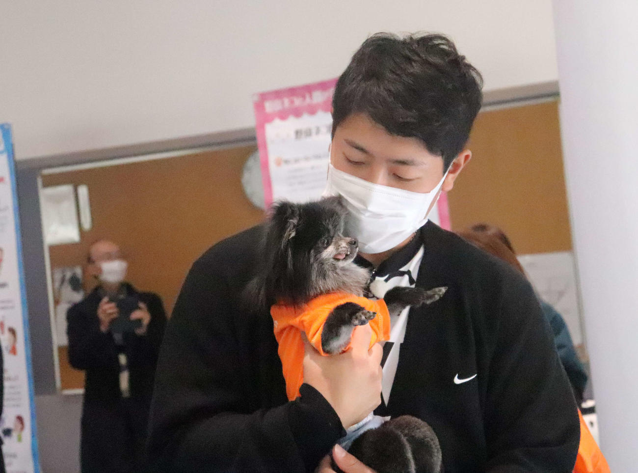 日本動物福祉協会の犬猫譲渡会に出席し、犬を抱きかかえる巨人岡本和（撮影・小早川宗一郎）