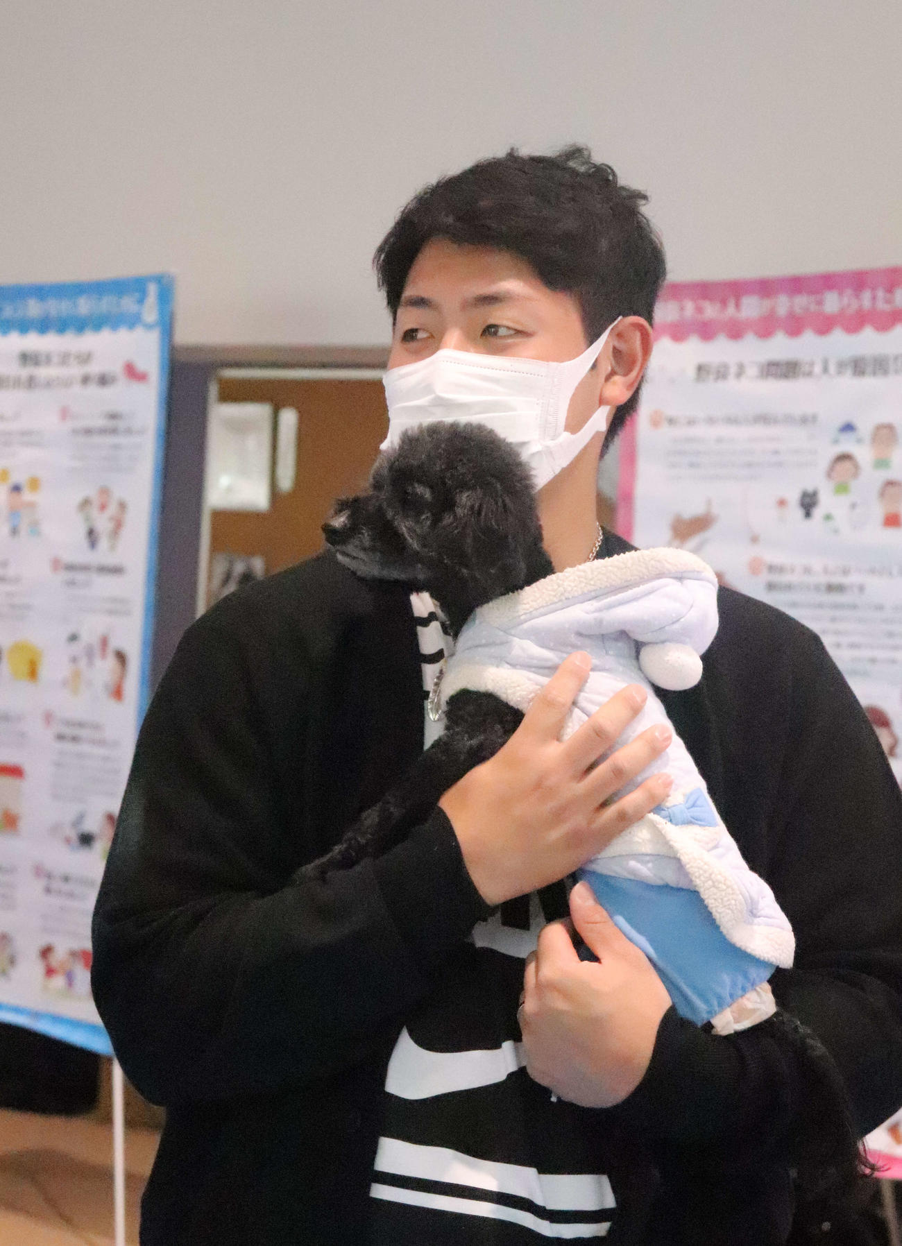 犬を抱きかかえる巨人岡本和（撮影・小早川宗一郎）