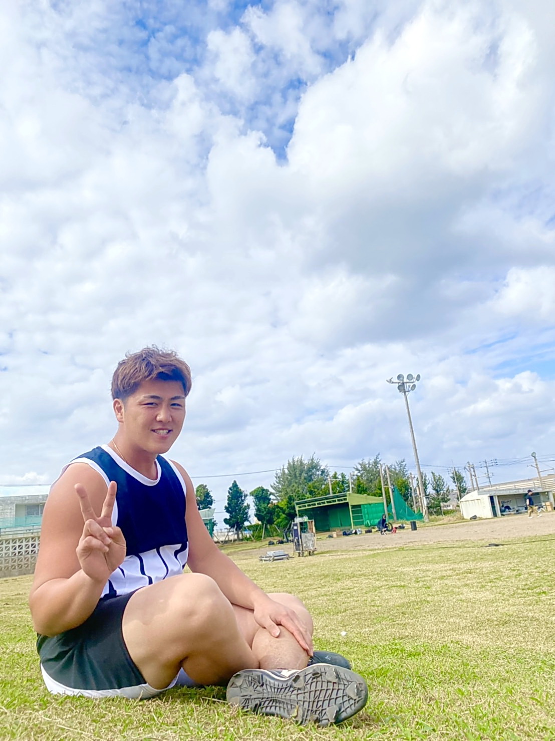 沖縄県内での自主トレ中に青空の下でVサインで優勝を誓うロッテ山口（球団提供）
