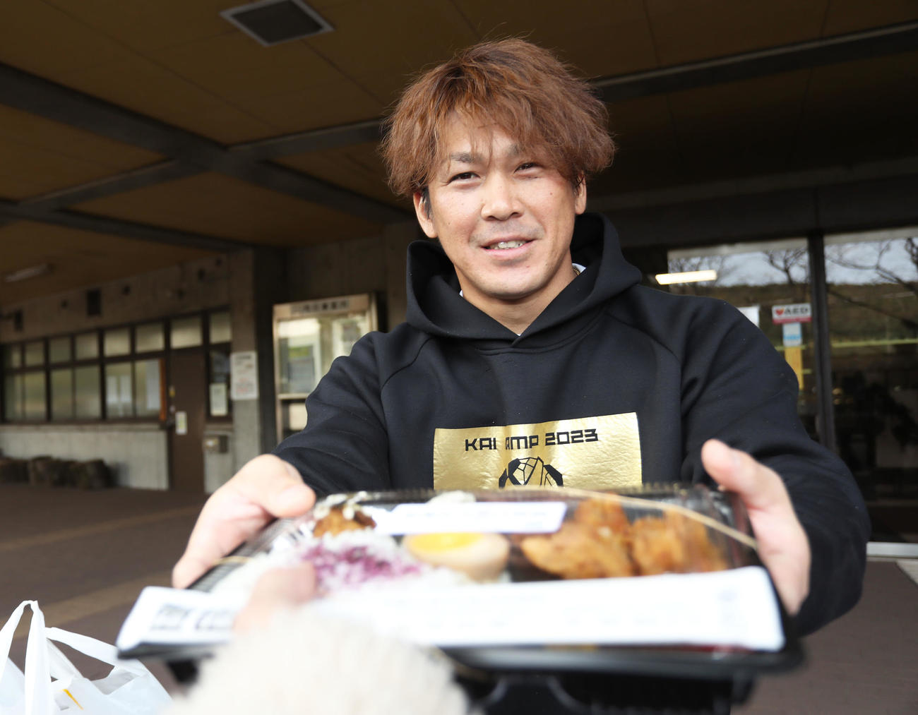 報道陣へお弁当の差し入れをする甲斐（撮影・屋方直哉）