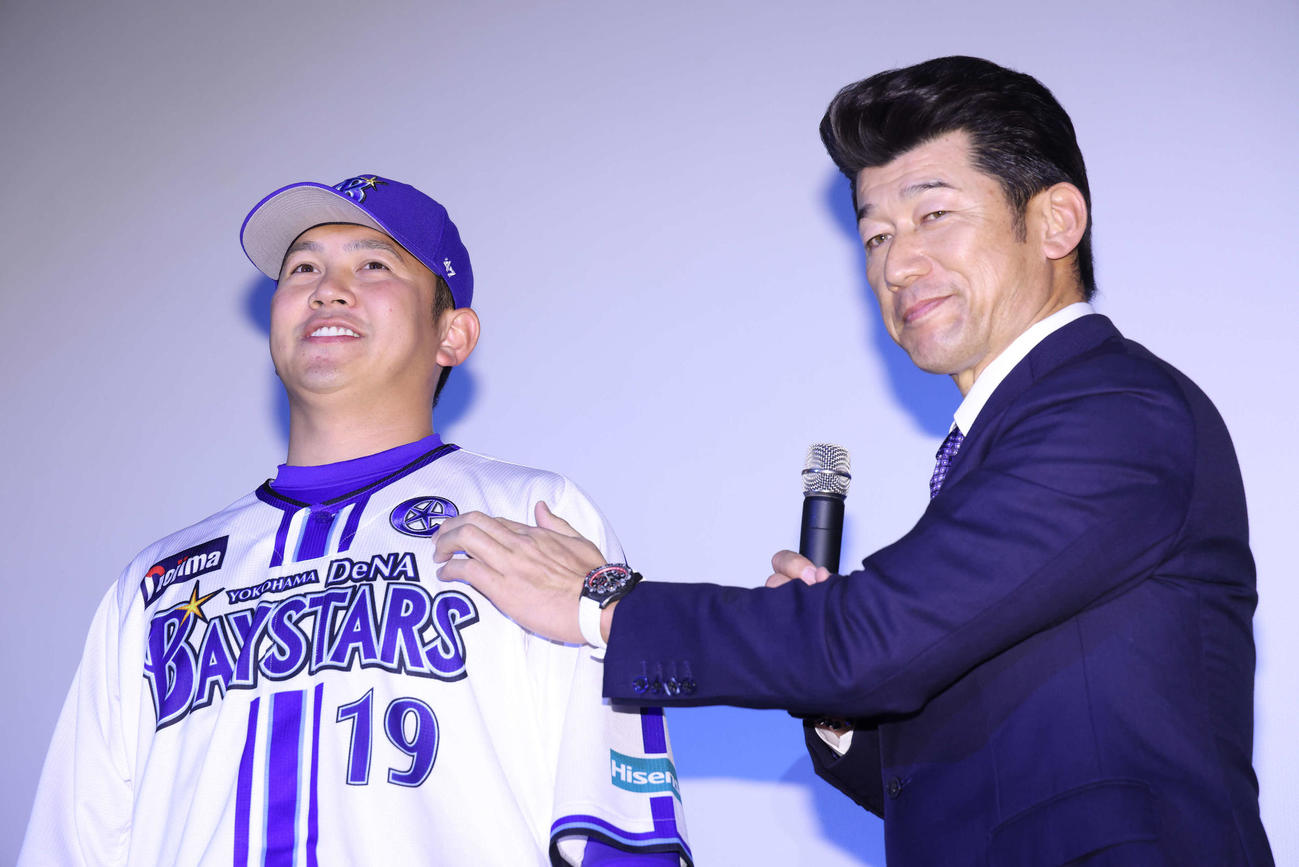 投手キャプテンマークをDeNA山崎（左）に着ける三浦監督（撮影・河田真司）
