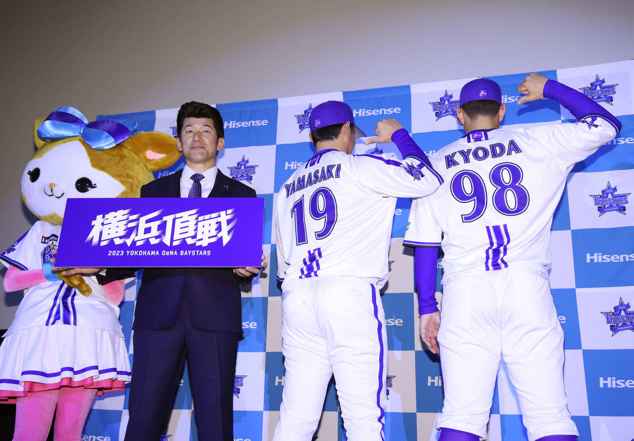 2023年シーズンスローガン「横浜頂戦」ボードを手に写真に納まるDeNA三浦大輔監督（左）と、新ホームユニホームを指さす山崎（中央）、京田（右）（撮影・河田真司）