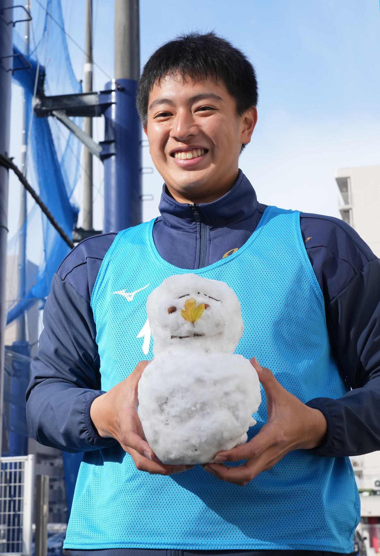 報道陣が作成した雪だるまを手に明るい表情を見せる仲地（撮影・森本幸一）