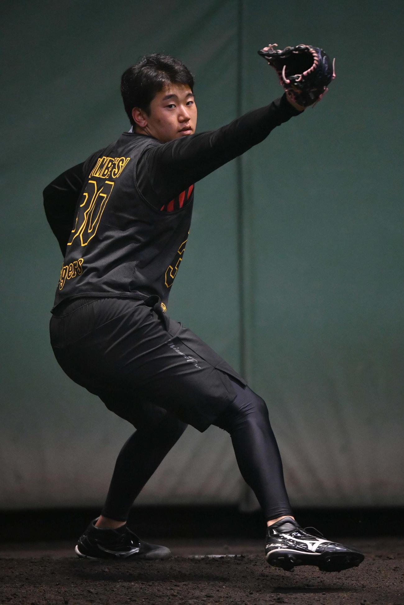 甲子園球場のブルペンで投球練習をする門別
