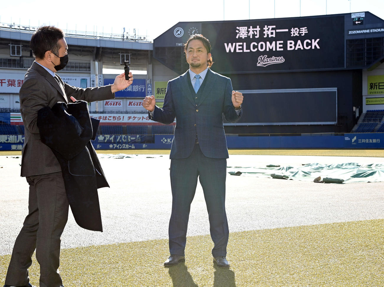 「WELCOME BACK」のボードを背にポーズを決めるロッテ沢村（撮影・たえ見朱実）