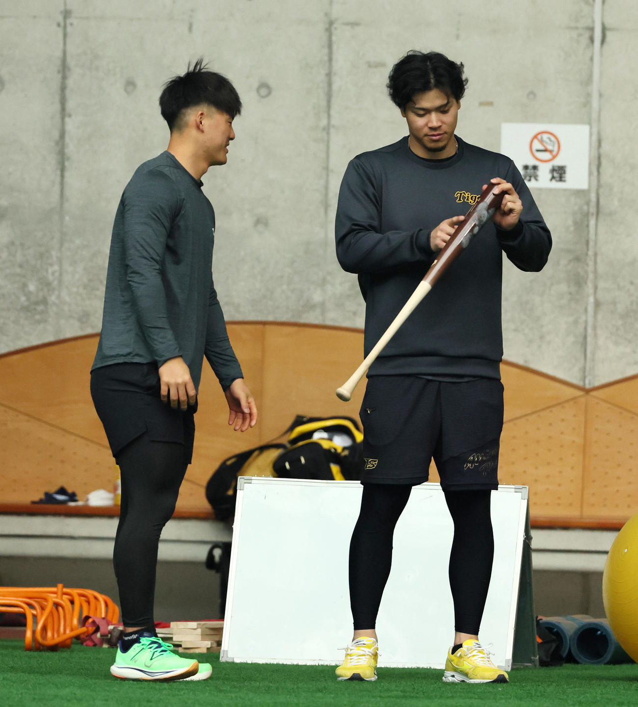 室内でバットを見る阪神佐藤輝。左は前川（撮影・加藤哉）