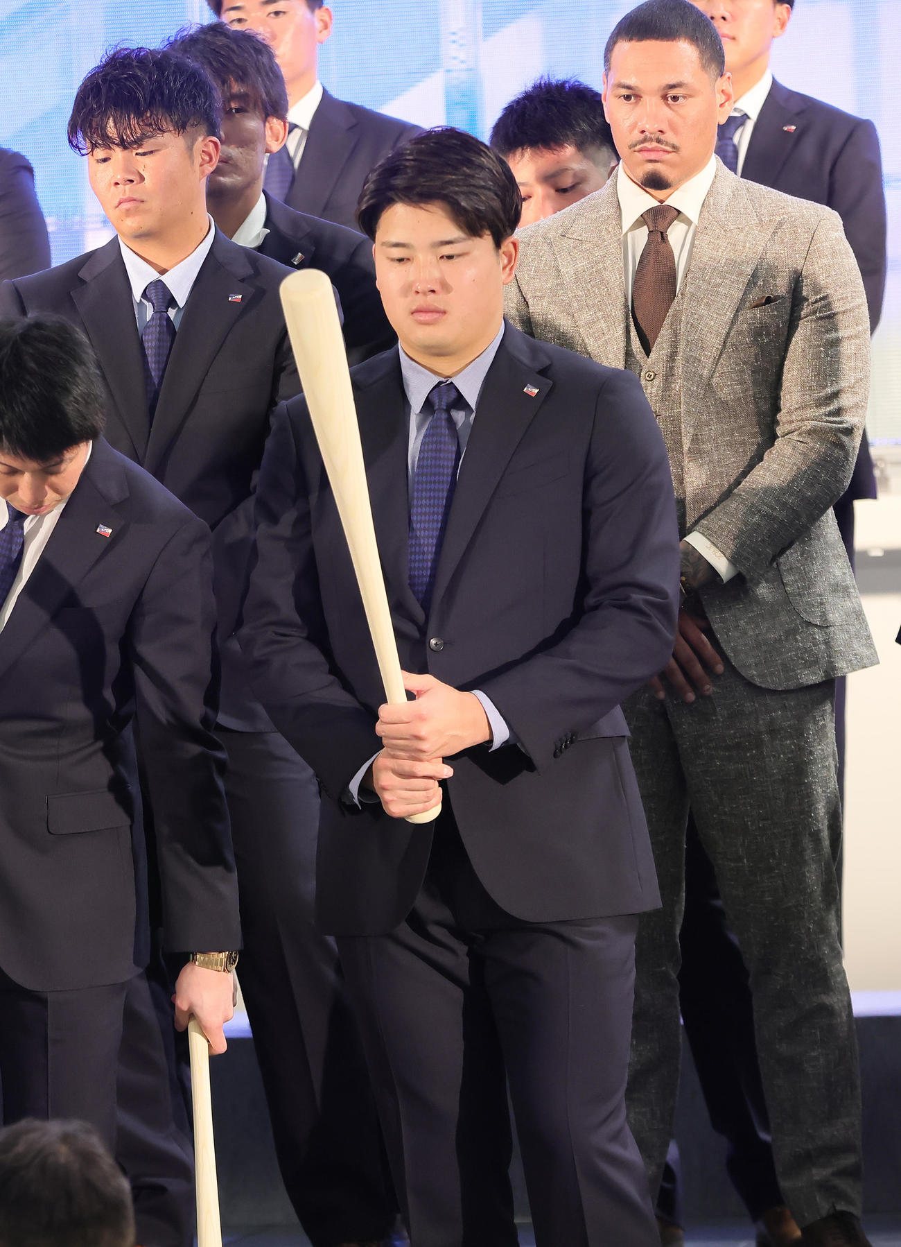 歓迎セレモニーでファンにプレゼントするバットを見つめる村上（撮影・足立雅史）