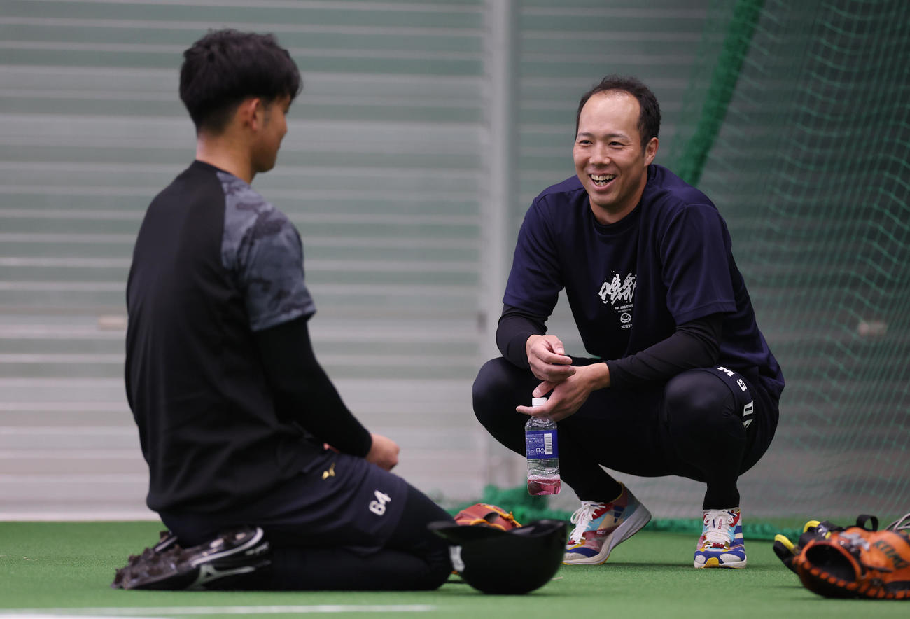 ブルペンで投球練習を終えた阪神岡留（左）と言葉を交わす青柳（撮影・前田充）