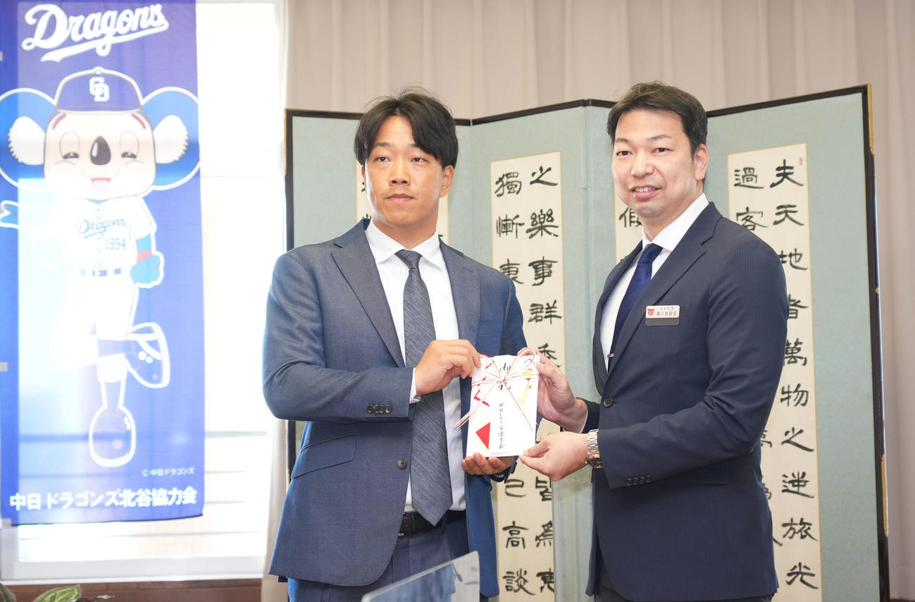 キャンプインを前にキャンプ地沖縄北谷町の役場を訪問し渡久地政志町長に目録を渡す中日柳裕也（左）（撮影・森本幸一）