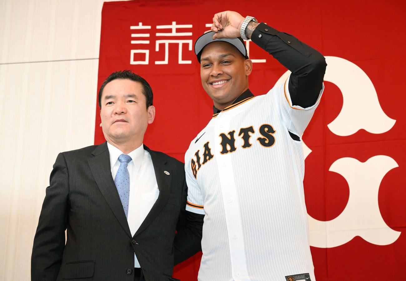 入団会見で記念撮影する巨人新外国人選手のルシアーノ（右）と大塚副代表（撮影・滝沢徹郎）