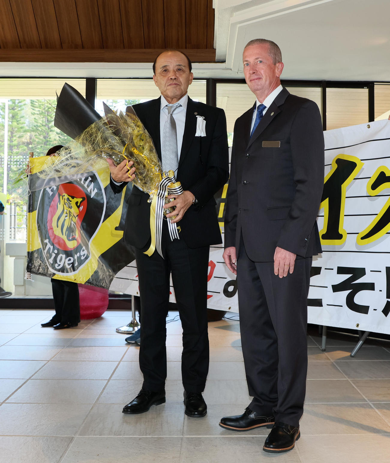 沖縄キャンプの宿舎に到着し花束を受け取る岡田監督（撮影・加藤哉）