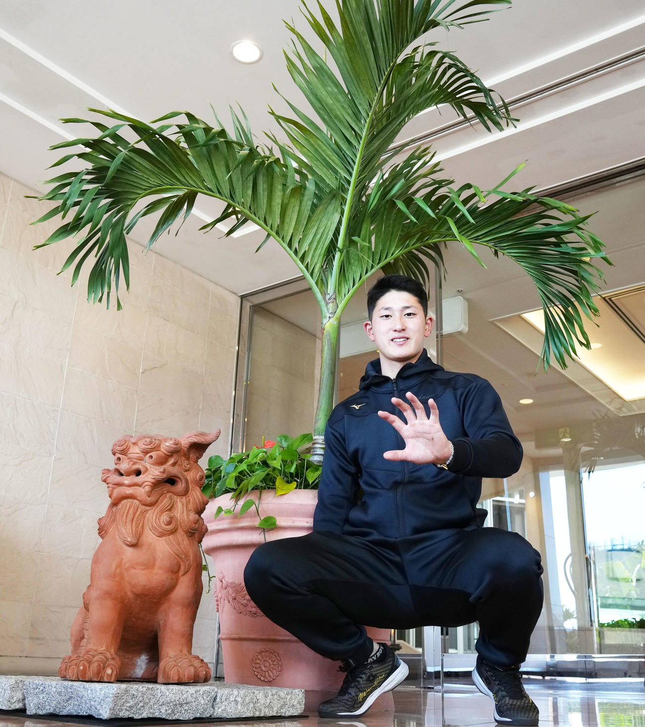 シーサーを横に笑顔を見せるDeNA松尾（撮影・横山健太）