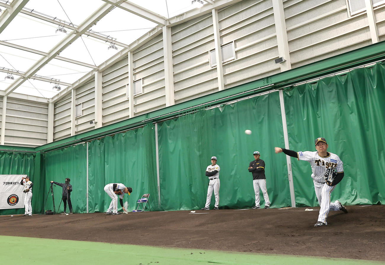 キャンプイン初日、一番乗りでブルペンに入りする西勇（右）（撮影・上山淳一）