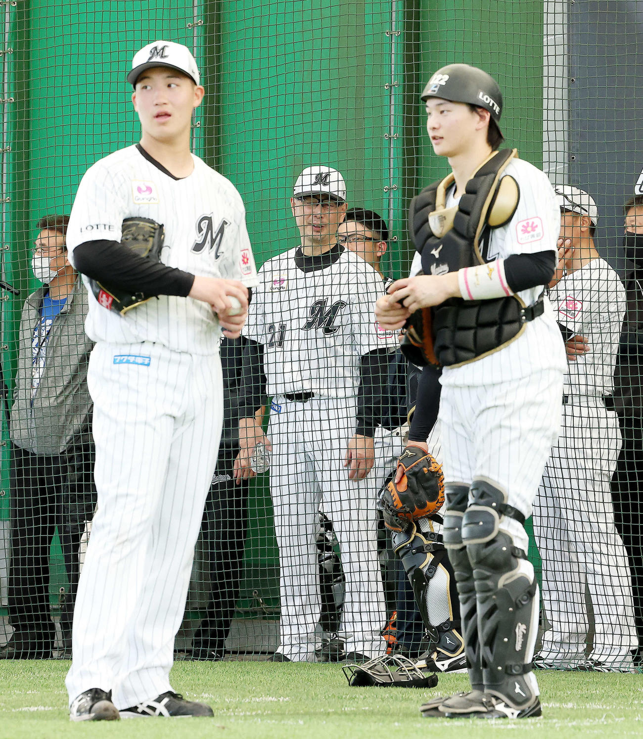 ブルペンに入る投手陣を見る吉井監督（後方中央）。手前左はロッテ菊地（撮影・河田真司）