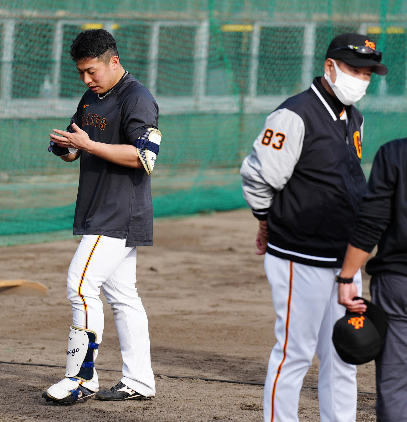 打撃練習後、左手のひらを見つめる巨人浅野。右は原監督（撮影・江口和貴）