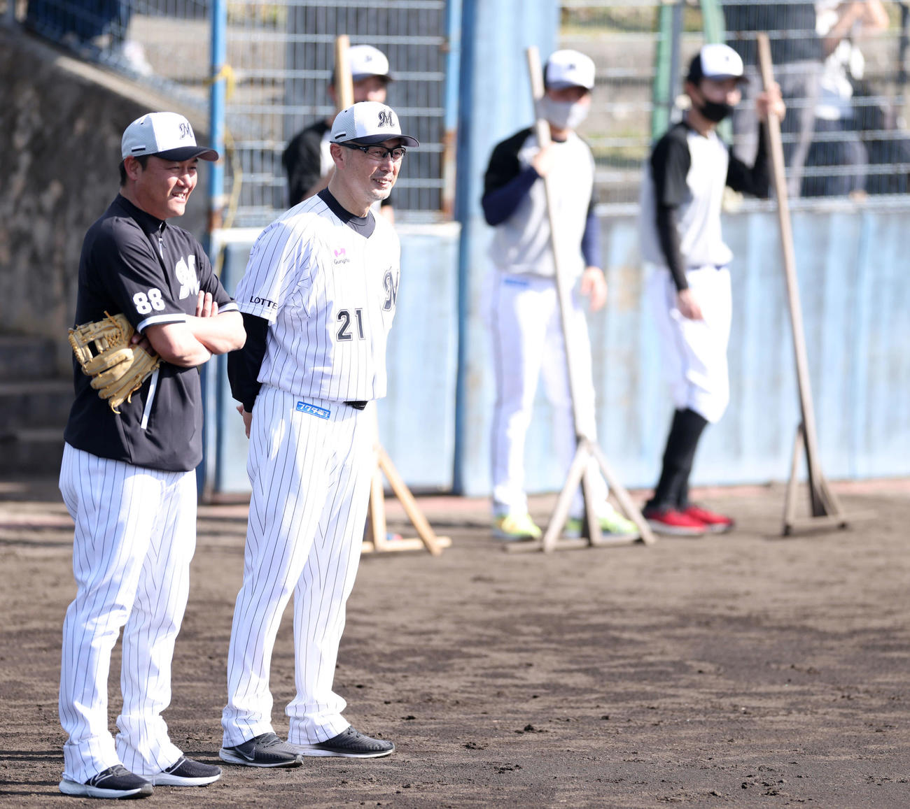 金子戦略コーチ（左）と笑顔で言葉を交わすロッテ吉井監督（撮影・河田真司）
