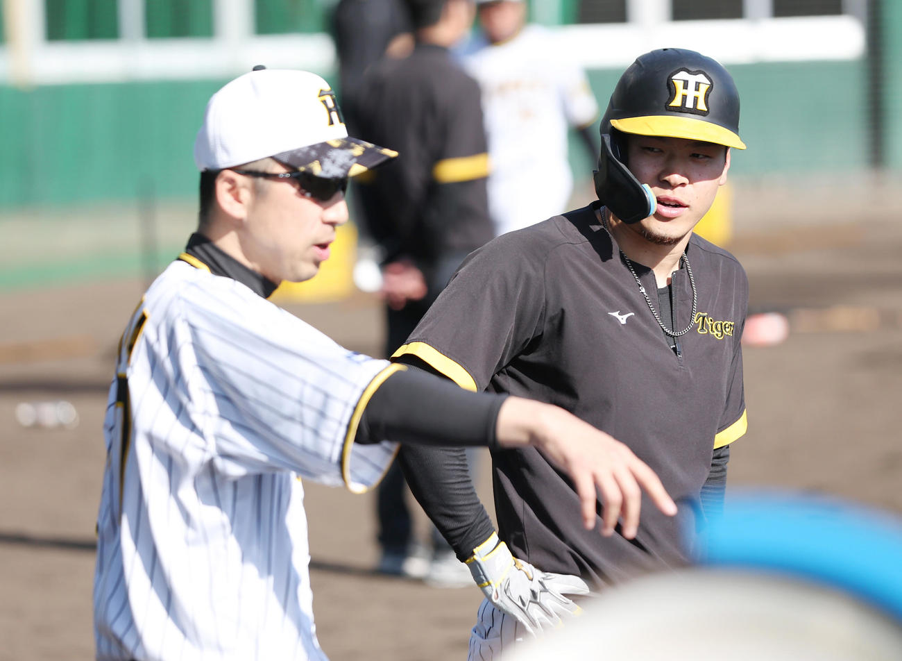 阪神今岡打撃コーチ（左）から指導を受ける佐藤輝（撮影・前田充）