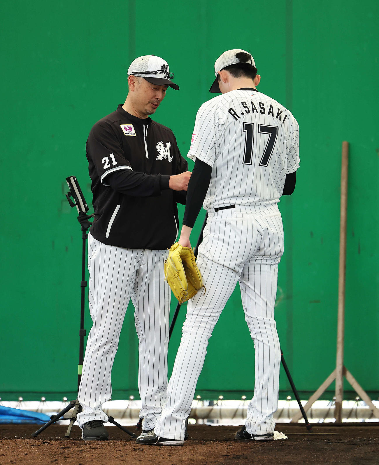 ブルペンで吉井監督（左）のアドバイスを受けるロッテ佐々木朗（撮影・河田真司）
