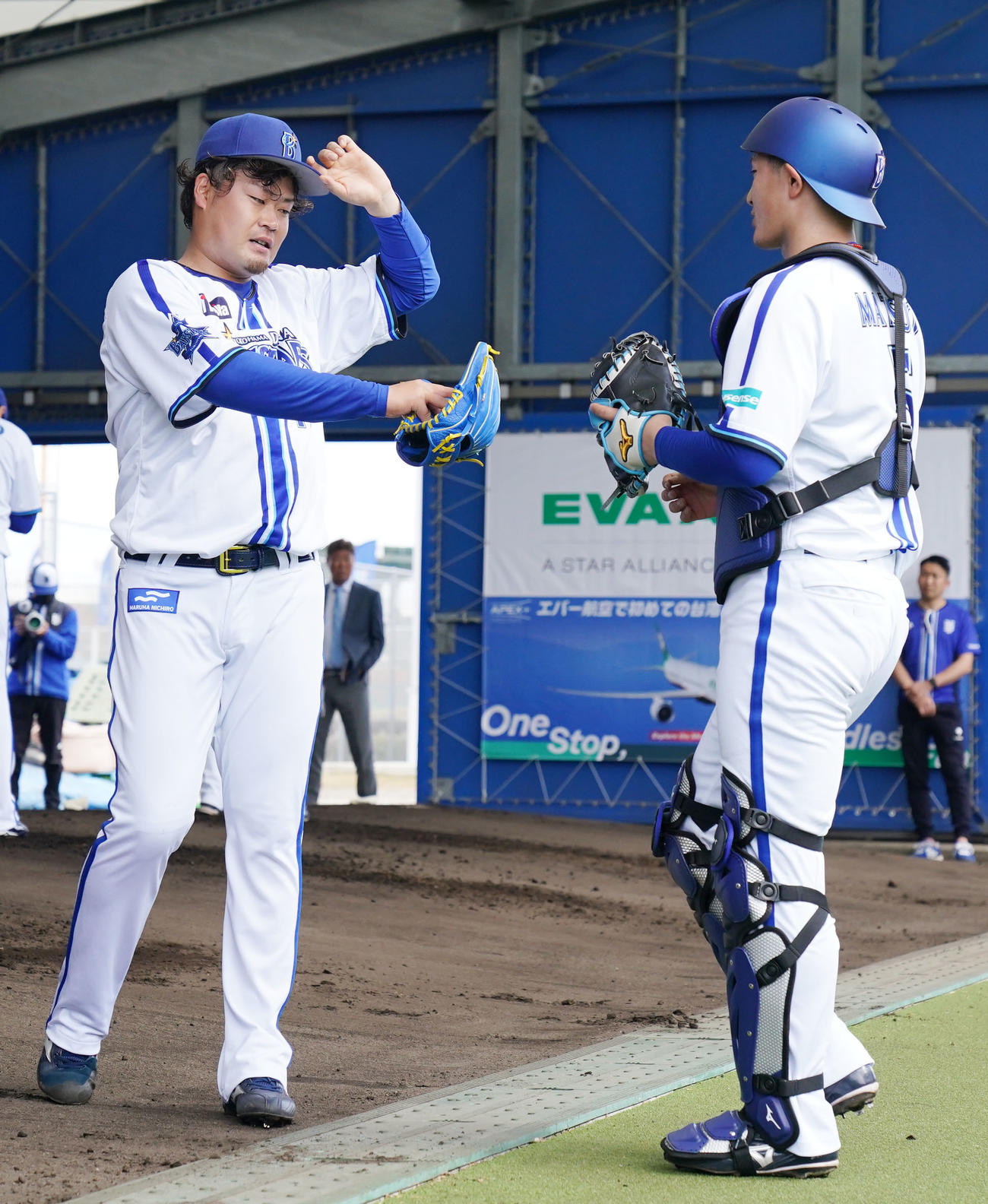 ブルペンでの投球練習を終えタッチを交わすDeNA伊勢（左）と松尾（撮影・横山健太）