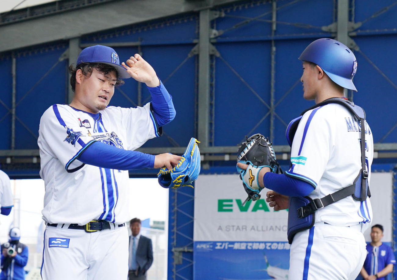ブルペンでの投球練習を終えタッチを交わすDeNA伊勢（左）と松尾（撮影・横山健太）