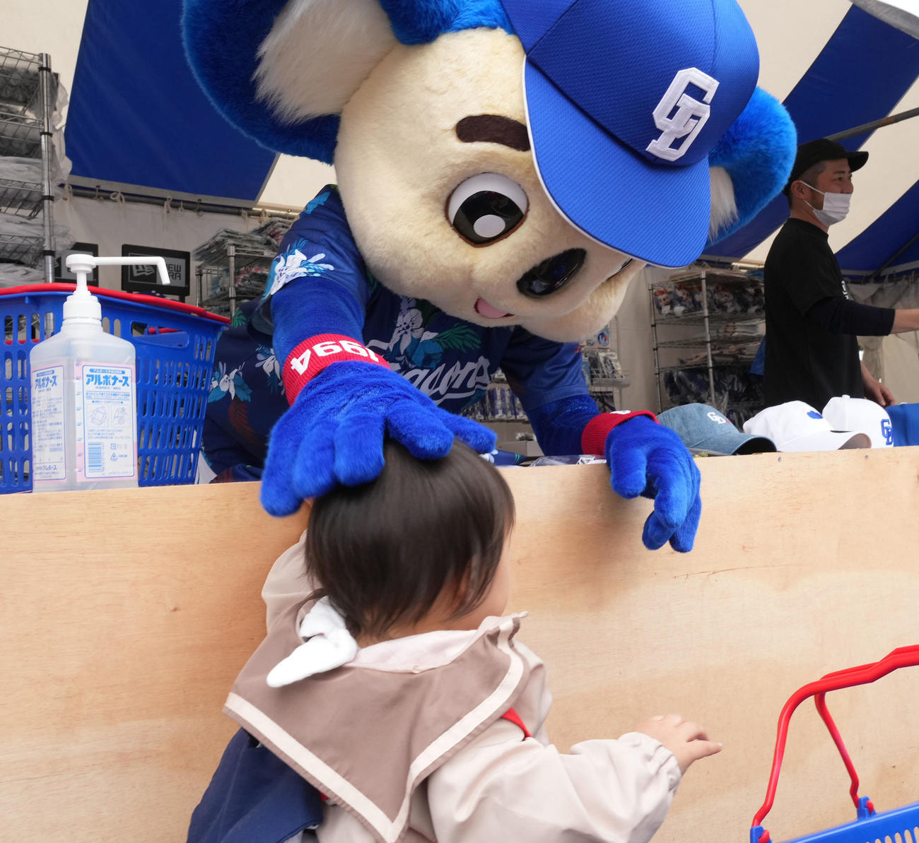 グッズ売店で子供の頭をなでるドアラ（撮影・森本幸一）
