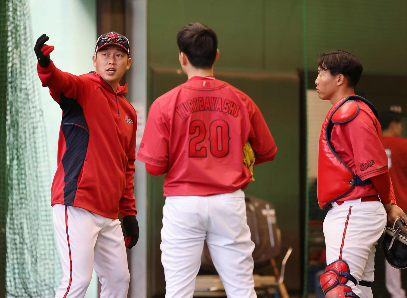 ブルペンで栗林（中央）を指導する新井監督。右は石原（撮影・加藤孝規）