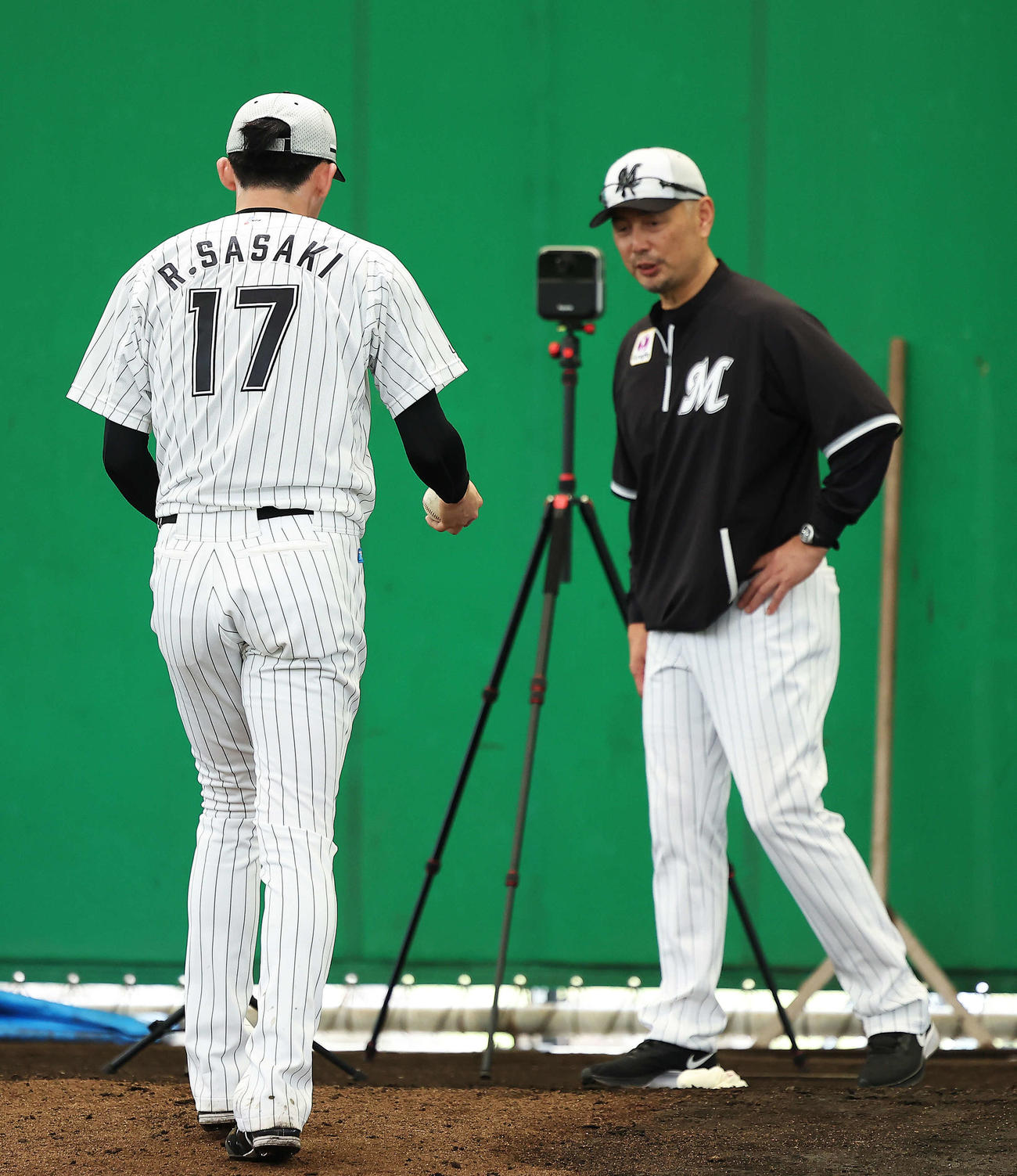 ブルペンでロッテ佐々木朗希（左）は吉井理人監督と言葉を交わす（撮影・河田真司）